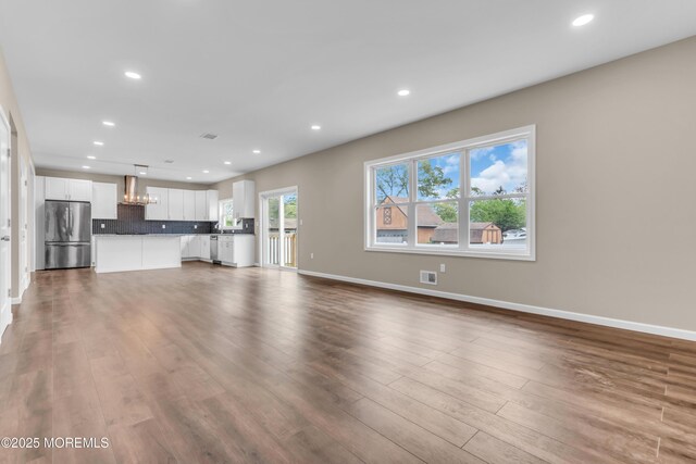 unfurnished living room featuring dark wood finished floors, recessed lighting, and baseboards