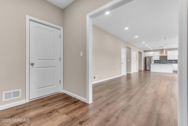 unfurnished living room featuring wood finished floors, baseboards, and recessed lighting
