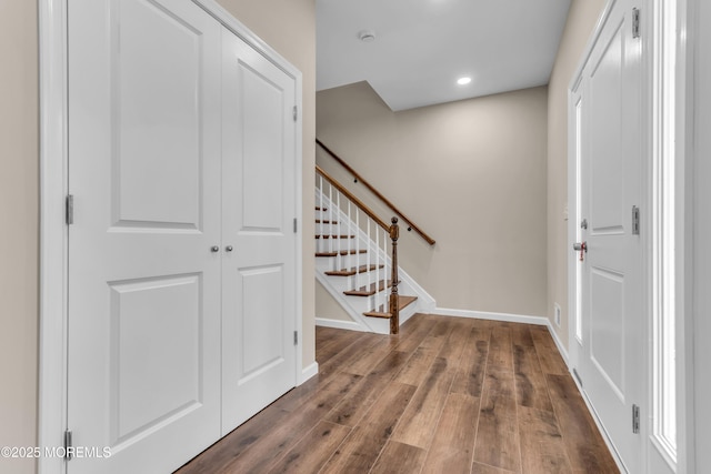 entrance foyer with wood finished floors, baseboards, stairway, and recessed lighting
