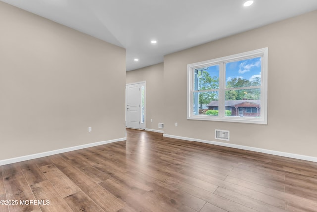 spare room featuring wood finished floors, recessed lighting, and baseboards