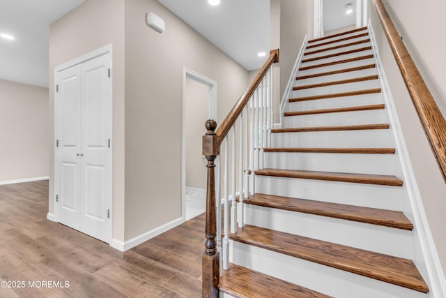 stairway featuring wood finished floors, recessed lighting, and baseboards