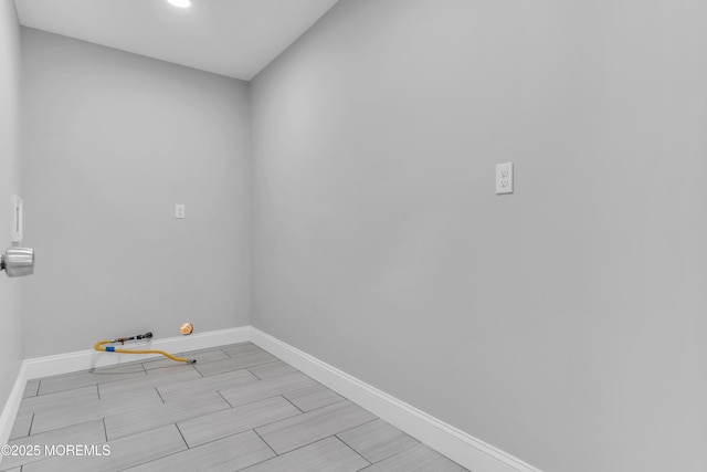laundry area featuring baseboards and wood finish floors