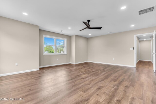 spare room featuring attic access, wood finished floors, recessed lighting, ceiling fan, and baseboards