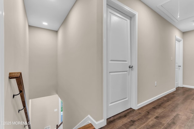 hallway with attic access, dark wood-style floors, and baseboards