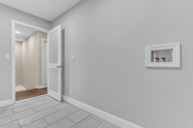 washroom featuring washer hookup, baseboards, and wood tiled floors
