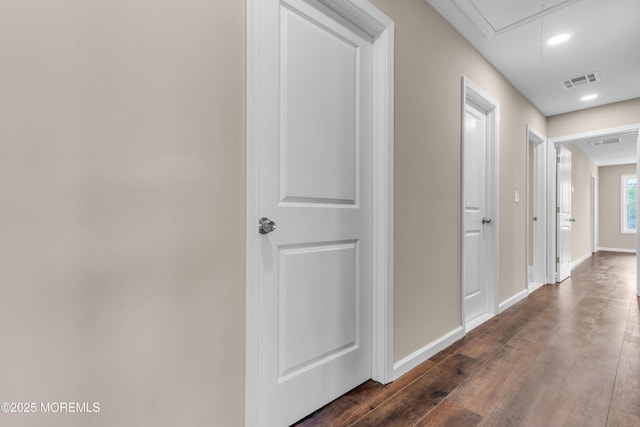 corridor featuring attic access, baseboards, dark wood-style floors, and recessed lighting