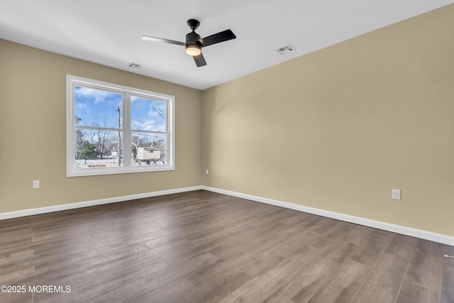 empty room featuring wood finished floors, baseboards, and ceiling fan