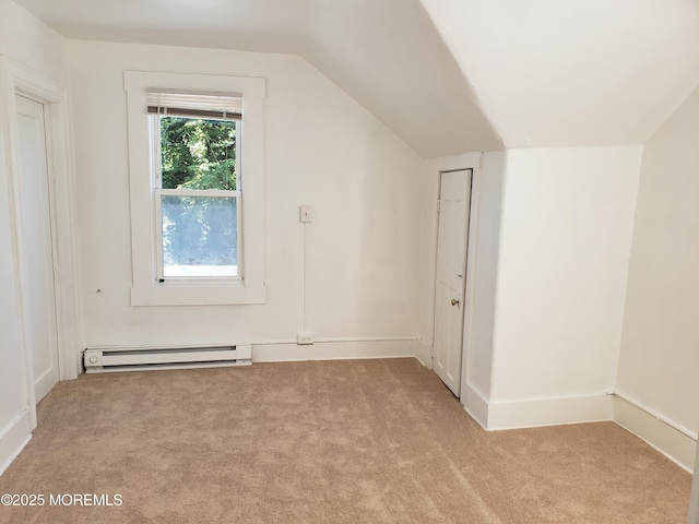bonus room featuring a baseboard heating unit, light colored carpet, and lofted ceiling