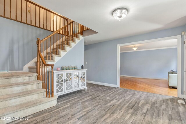 stairs featuring wood finished floors and baseboards