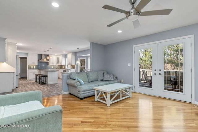 living area featuring light wood-style floors, recessed lighting, french doors, and a ceiling fan