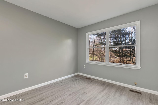 empty room with baseboards and wood finished floors