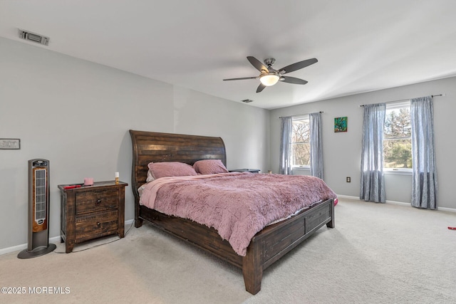 bedroom featuring light colored carpet, baseboards, and a ceiling fan