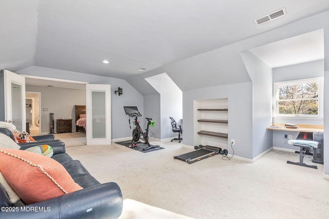 exercise area featuring vaulted ceiling, carpet, and baseboards
