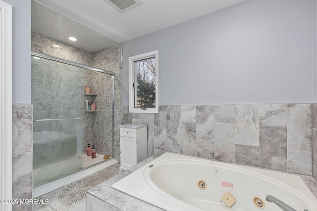 full bath with a whirlpool tub, a stall shower, and tile walls