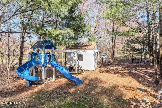 view of jungle gym with fence, a storage shed, and an outdoor structure