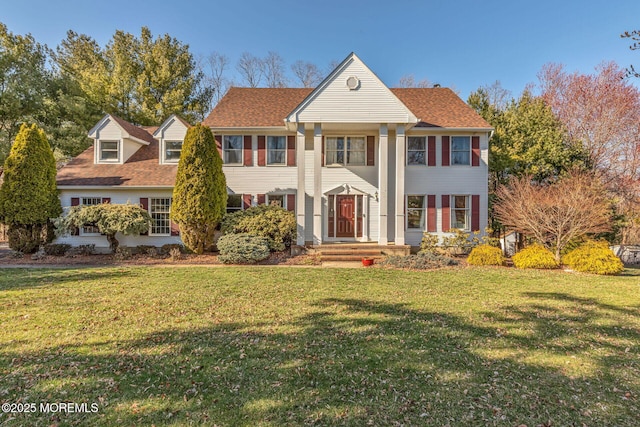 greek revival inspired property with a front lawn and roof with shingles