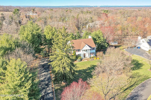 aerial view of property and surrounding area featuring a forest