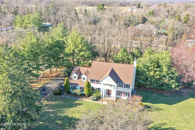 aerial view of property and surrounding area featuring a forest