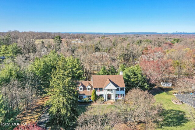 aerial view of property and surrounding area featuring a forest