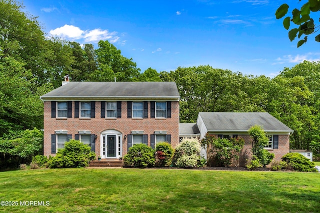 24 Statesboro Rd, Freehold, NJ 07728 - colonial-style house with brick siding, a front lawn, and a chimney