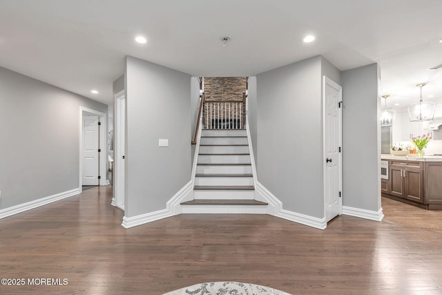 stairway featuring wood finished floors, recessed lighting, and baseboards