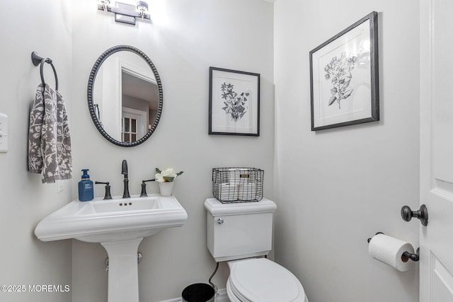 half bathroom featuring toilet and a sink