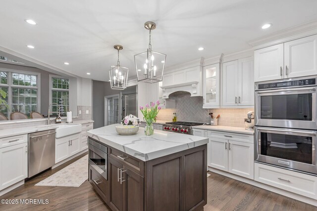 3 Ardmore Pl, Holmdel, NJ 07733 - kitchen featuring built in appliances, a sink, backsplash, a chandelier, and white cabinets