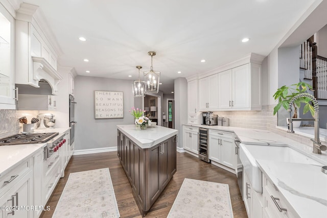 kitchen featuring a sink, beverage cooler, white cabinetry, appliances with stainless steel finishes, and recessed lighting