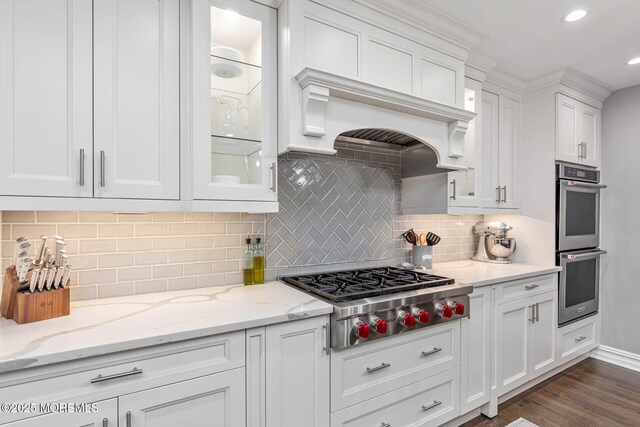 kitchen with appliances with stainless steel finishes, white cabinets, glass insert cabinets, dark wood-style floors, and recessed lighting
