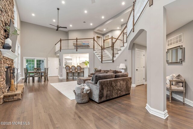 3 Ardmore Pl, Holmdel, NJ 07733 - living area featuring a high ceiling, stairs, a ceiling fan, a fireplace, and baseboards
