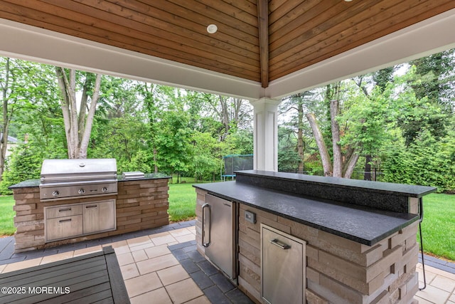 view of patio / terrace featuring area for grilling, a grill, and view of scattered trees