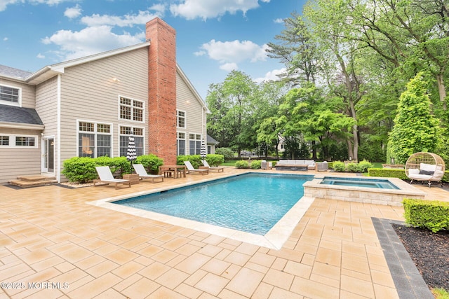 view of swimming pool featuring a patio and a pool with connected hot tub