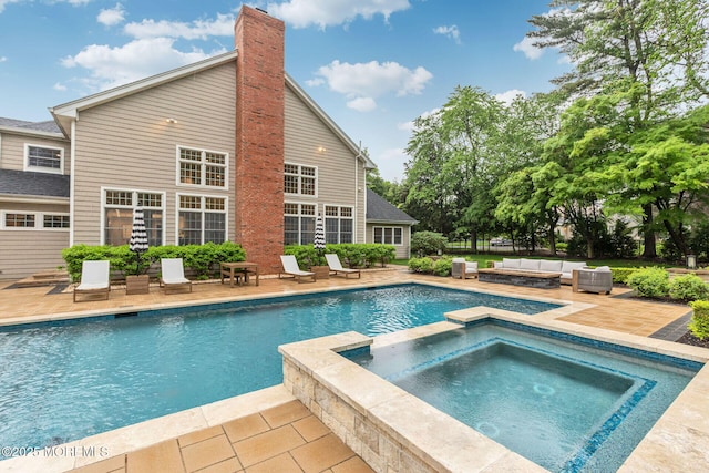 view of pool featuring a patio, outdoor lounge area, and a pool with connected hot tub