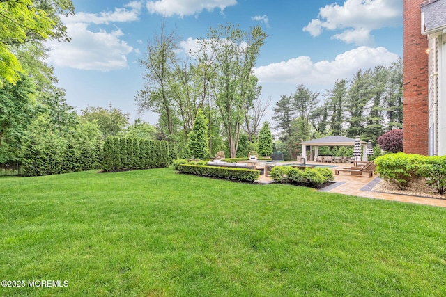 view of grassy yard with a gazebo and a patio