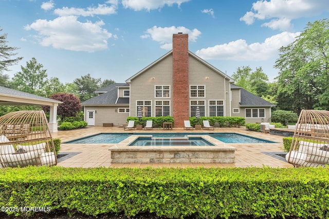 view of pool featuring a patio, a gazebo, and a pool with connected hot tub