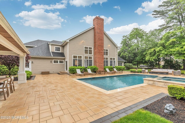 view of swimming pool with a patio area and a pool with connected hot tub