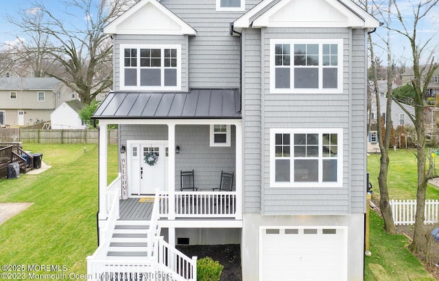 view of front facade with a standing seam roof, an attached garage, a porch, metal roof, and stairs
