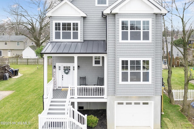 coastal inspired home with an attached garage, a porch, a standing seam roof, metal roof, and stairway