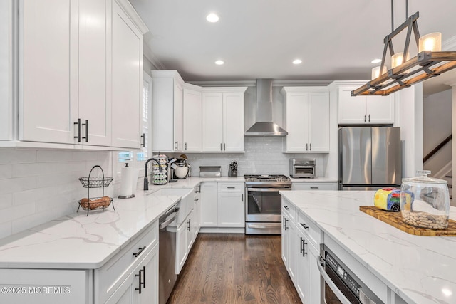 kitchen with appliances with stainless steel finishes, wall chimney exhaust hood, recessed lighting, white cabinets, and dark wood-style flooring