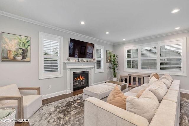living room with ornamental molding, dark wood finished floors, recessed lighting, baseboards, and a lit fireplace