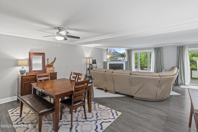 142 Orchid Ct, Toms River, NJ 08753 - dining room with dark wood-style floors, ornamental molding, a fireplace, ceiling fan, and baseboards