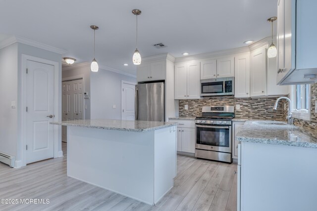 129 Guadeloupe Dr, Toms River, NJ 08757 - kitchen featuring stainless steel appliances, a sink, crown molding, light wood-style flooring, and decorative backsplash