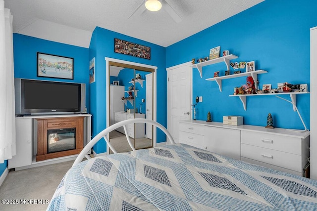 bedroom with carpet flooring, a closet, a ceiling fan, and a textured ceiling