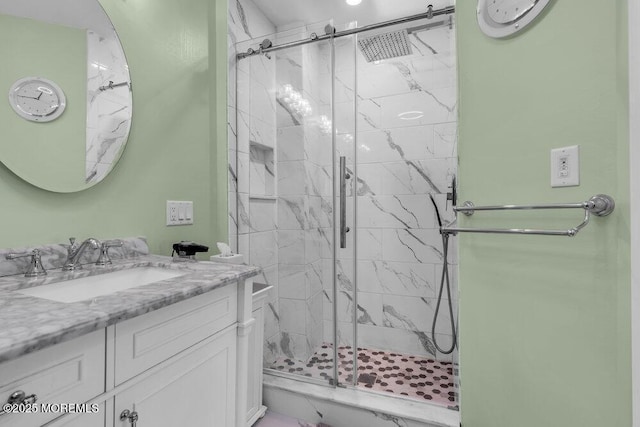 bathroom featuring a marble finish shower and vanity
