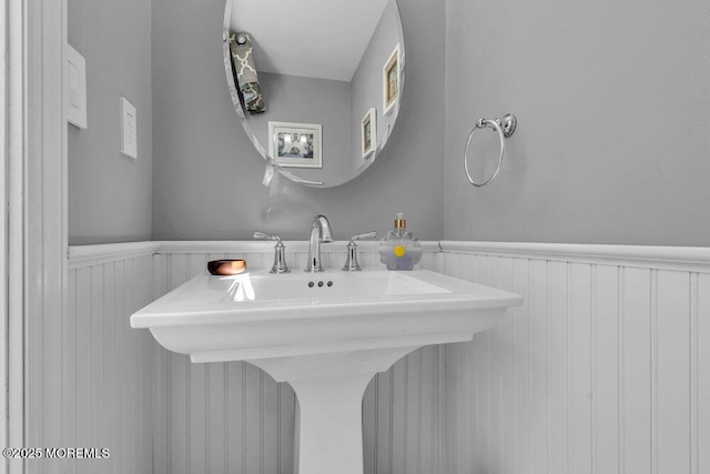 bathroom featuring a wainscoted wall and a sink