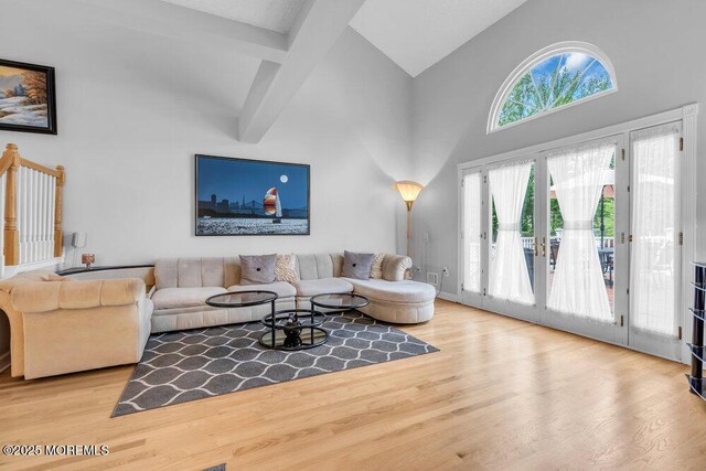 living room with high vaulted ceiling, wood finished floors, and beam ceiling
