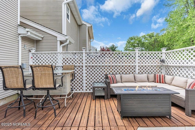 wooden terrace featuring an outdoor living space with a fire pit and outdoor dining area
