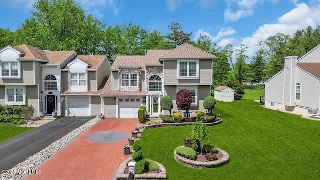 view of front of home featuring driveway, an attached garage, and a front yard