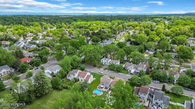 view of property location featuring nearby suburban area and a heavily wooded area