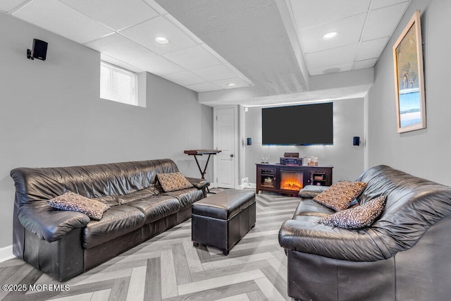 living area featuring recessed lighting, baseboards, and a paneled ceiling